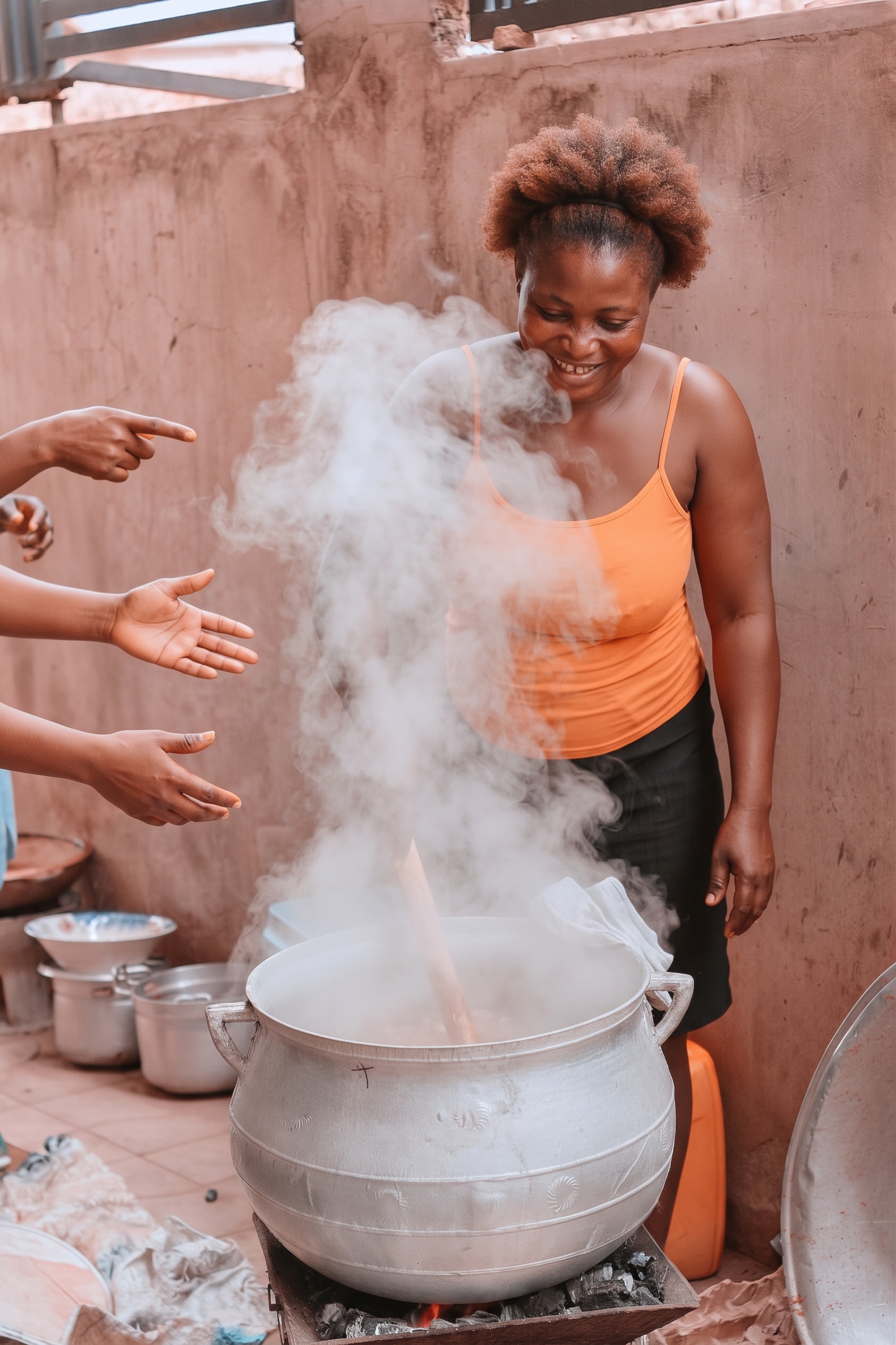 A smiling woman beside a steaming cooking pot